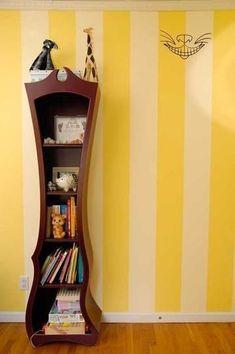 a tall wooden shelf sitting next to a yellow and white striped wall in a child's room