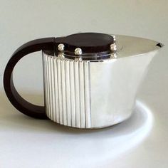 a white and black coffee pot sitting on top of a table