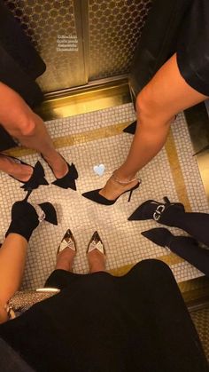 several people standing in a circle with their feet on each other's ankles and wearing high heeled shoes