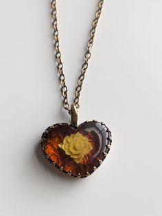 A heart shaped pendant holding a rose carved in amber. This pendant is bezel set in brass gallery wire which gives it a 👑 royal touch 👑 Chain can be  14' 16' or 18' in length please select your option at checkout Feel free to message me with any questions! :) *All purchases come gift wrapped & with a free polishing cloth to maintain the finish & shine of the peice* Holding A Rose, Amber Heart, Heart Shaped Pendant, Heart Shape Pendant, A Rose, Bezel Setting, A Heart, Pendant Necklaces, Heart Pendant