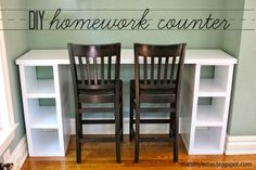 two wooden chairs sitting next to each other in front of a white book shelf with writing on it