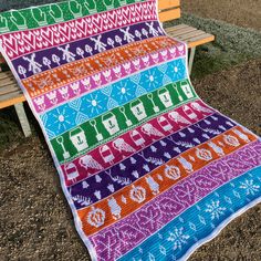 a colorful blanket sitting on top of a wooden bench