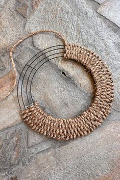 three pieces of woven rope sitting on top of a rock