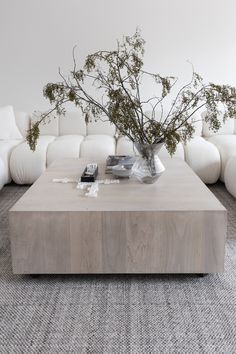 a living room with white couches and a coffee table in front of the couch