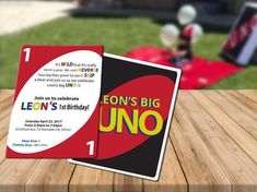 an uno card sitting on top of a wooden table in front of a lawn area