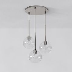 three clear glass globes hanging from a ceiling fixture