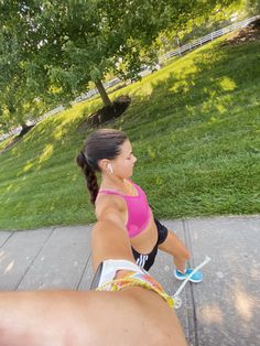 a woman in pink shirt riding on top of a skateboard next to another person