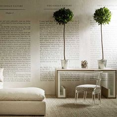 two potted plants sit on top of a bed in front of a wall with words