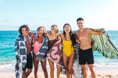 a group of people standing next to each other on a beach