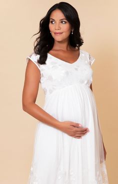 The stunning embroidered lace detailing on this very pretty new maternity wedding dress is the star of the show. A soft ivory clover leaf design adorns the hem of the dress, and gently graduates until it disappears. The front and back bodice are mirrored with a soft v-neckline and matching clover leaf lace. Cap sleeves are edged in satin binding and the floor length maternity dress is twice-lined in breathable and soft-to-the-skin fabrics. / Clover leaf lace embroidered skirt and bodice / Sheer Elegant White Maternity Dress With Lace Trim, Fitted Cream Maternity Dress For Wedding, Elegant White Maternity Bridesmaid Dress, Elegant White Maternity Gown, Elegant White Maternity Wedding Dress, Lace Maternity Dress With Lace Bodice For Wedding, Wedding Maternity Dress With Lace Bodice, White Lace Maternity Dress With Lace Trim, Maternity Wedding Dress With Lace Bodice