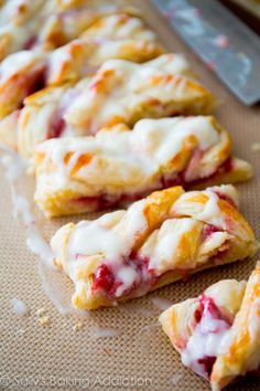 raspberry scones are lined up on a baking sheet and ready to be eaten