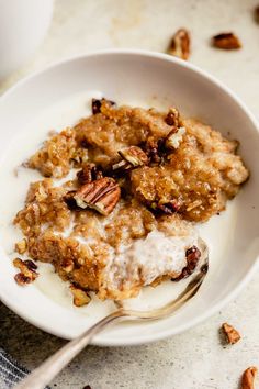 a bowl filled with oatmeal and pecans on top of a table