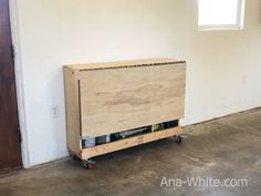 a wooden box sitting on top of a dolly in an empty room next to a door