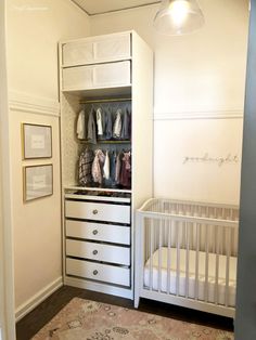 a baby's crib is next to a white dresser with drawers and clothes on it