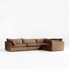 a large sectional couch with pillows on the top and bottom, sitting in front of a white background