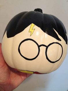 a close up of a person holding a pumpkin with a harry potter face on it