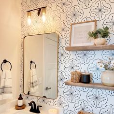 a white sink sitting under a bathroom mirror next to a wall mounted faucet