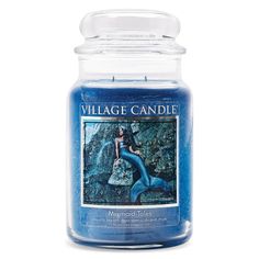 a blue candle that is sitting in front of a white background with the words village candle on it