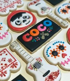 decorated sugar cookies are arranged in the shape of guitars and skull heads with colorful decorations on them