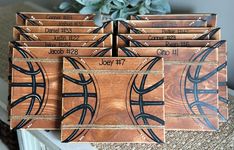 four wooden coasters with basketball designs on them sitting next to a potted plant