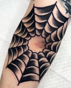 a man's arm with a spider web tattoo on it