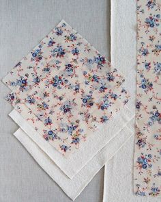 four napkins with flowers on them sitting next to each other