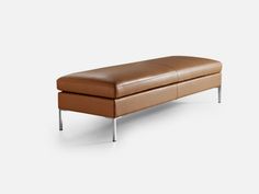 a brown leather bench sitting on top of a white floor