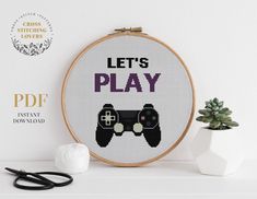 a cross stitch pattern with the words let's play and two video game controllers