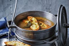 a pot filled with soup and bread on top of a stove