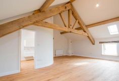 an empty room with wooden beams and white walls