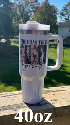 the eras tour travel mug is sitting on a deck