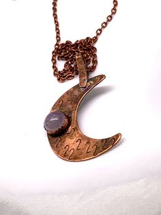 Handmade. Hammered Copper About 3 inches tall. Each piece is one of a kind. AMETHYST STONE is 8mm in diameter.   The crescent moon pendant, meticulously shaped from copper, adds a touch of rustic elegance, while the deep purple amethyst gemstone, symbolizing spiritual wisdom and tranquility, takes center stage. Each necklace is a one-of-a-kind masterpiece, reflecting the artistry of handmade jewelry. Whether you're dressing up for a special occasion or seeking to infuse your everyday style with Copper Necklace Pendant, Spiral Pendant, Energy Jewelry, Amazonite Necklace, Branson Mo, Crescent Moon Pendant, Goddess Energy, Spiritual Wisdom, Silver Jewelry Pendant