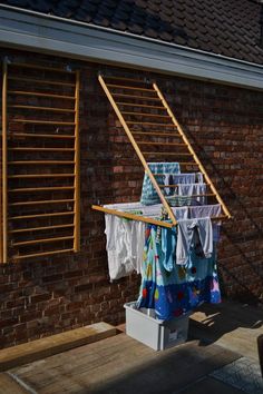 clothes hanging out to dry in the sun on a clothes line outside a brick building