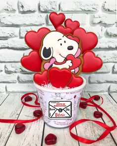 a cup filled with ice cream sitting on top of a wooden table next to a red ribbon