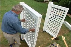 a man is working on an outdoor trellis