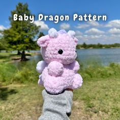 a person holding a pink teddy bear in their hand with the caption baby dragon pattern