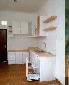 an empty kitchen with white cabinets and wood flooring is pictured in this image, there are no people around