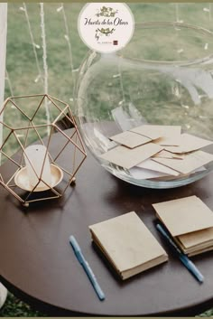 there is a glass bowl with notepads on the table