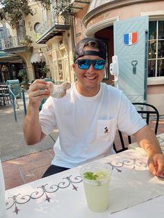 a man sitting at a table with food in front of him and wearing sunglasses on his head