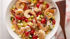 a white bowl filled with shrimp, corn and tomatoes