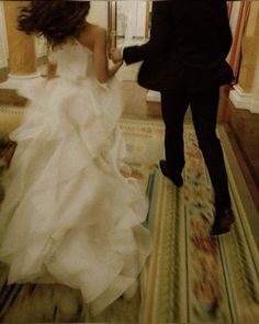 a bride and groom are walking down the hall