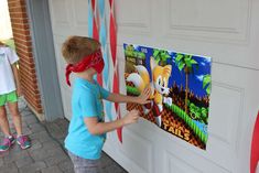 a little boy that is standing in front of a wall with some tape on it