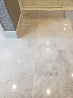 a bathroom with marble flooring and white walls