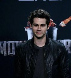 the young man is standing in front of a movie poster