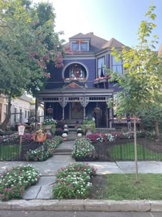 a blue house with lots of flowers in the front yard