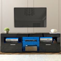 an entertainment center with a large television mounted on the wall and two blue drawers in front of it