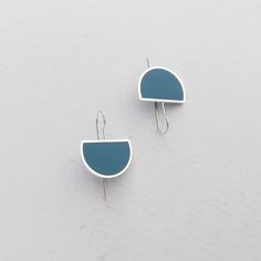 two pairs of earrings with blue and white shapes