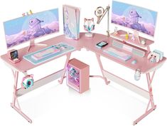 a pink desk with two computer monitors on top of it and a game controller next to it