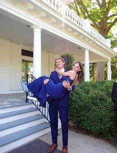 a man in a blue suit is holding a woman