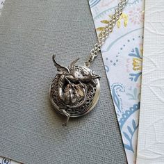 Gargoyle Dragon Guardian Protection Locket ☻Locket ~ Round Silver ~ With Bronze Bunny ~ With Flower ~ See Photos for size comparison against American quarter Chain: ~ Silver Plated YOU CHOOSE YOUR CHAIN LENGTH during checkout ☻More Lockets Here: https://www.etsy.com/shop/FashionCrashJewelry/search?search_query=lockets&order=date_desc&view_type=gallery&ref=shop_search ☻Link to The ENTIRE SHOP: https://www.etsy.com/shop/FashionCrashJewelry?ref=shopsection_shophome_leftnav&ga_search Adjustable Sterling Silver Dragon Jewelry, Adjustable Sterling Silver Jewelry With Dragon Design, Collectible Metal Jewelry With Dragon Design, Adjustable Pewter Jewelry As Gift, Unique Adjustable Dragon Design Jewelry, Vintage Dragon Design Jewelry For Gifts, Vintage Dragon Design Jewelry Gift, Dragon Design Metal Jewelry, Vintage Jewelry With Dragon Design Gift